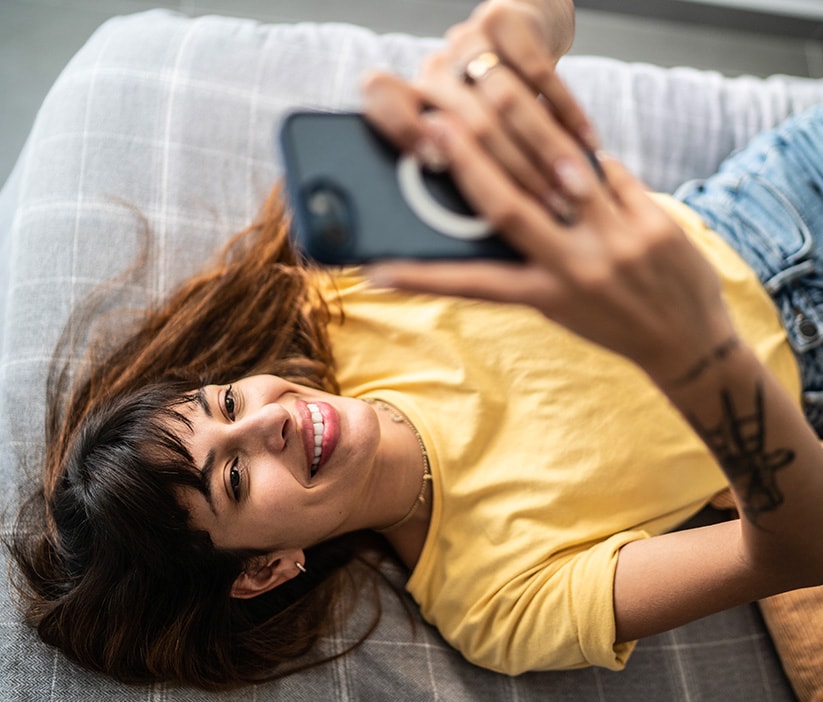 Une femme utilise son téléphone portable pour trouver comment supprimer des informations personnelles d’Internet.