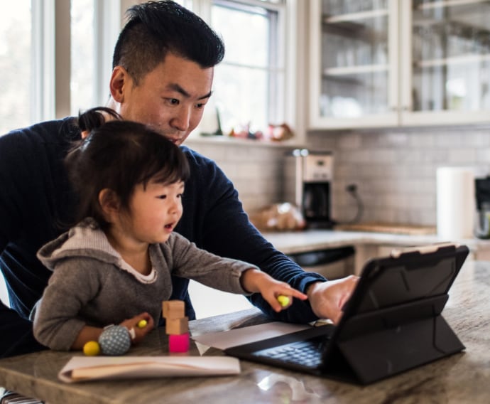 Père travaillant dans une cuisine avec sa fille.