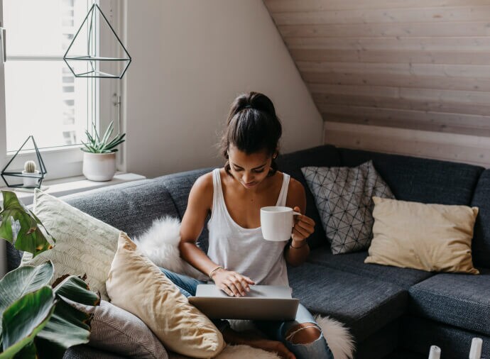 Homme se relaxant sur un canapé et utilisant son ordinateur portable