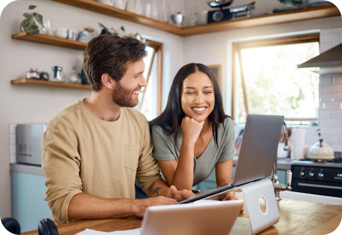 Jeune homme utilisant un ordinateur portable dans une cuisine.